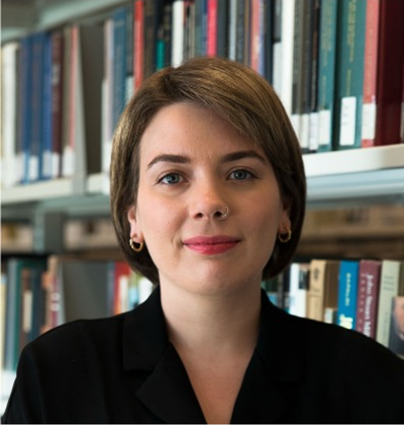 Graduate student Donna is a non-binary person with short, straight, light brown hair wearing red lipstick. She is photographed facing the camera straight and from the shoulders up and has a slight smile.